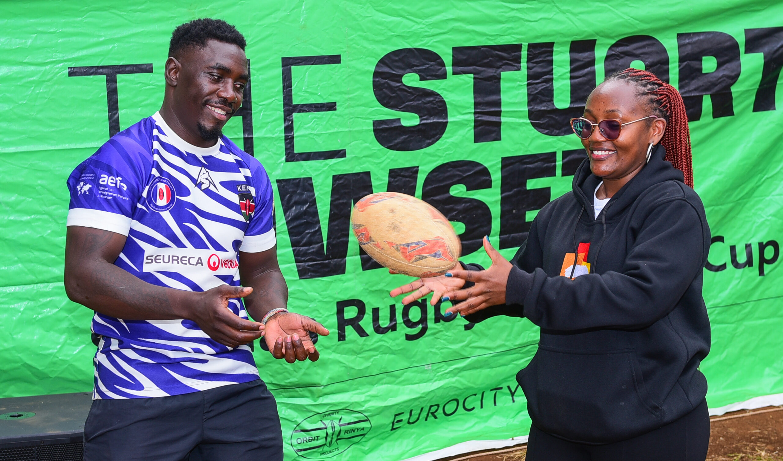 Joseph Alphi receives a trophy from Patience Nyange